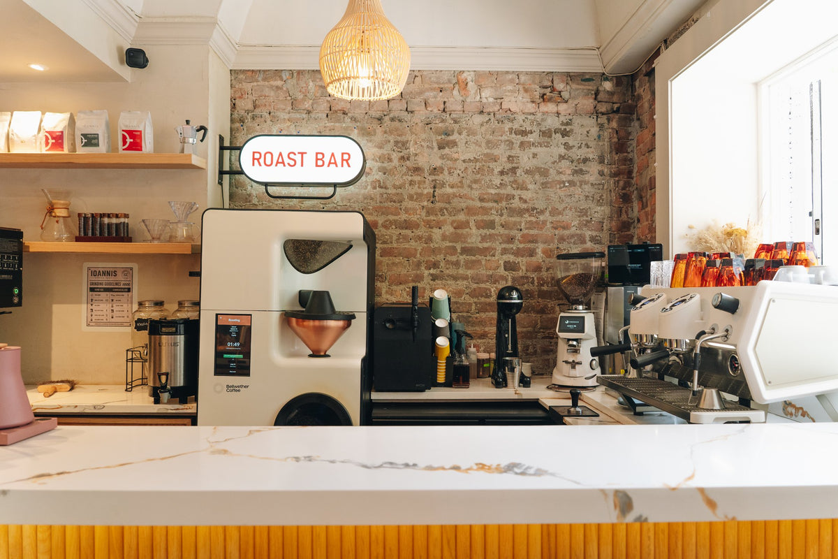The Ioannis Coffee Chef café counter with coffee roaster, espresso machine and exposed brick